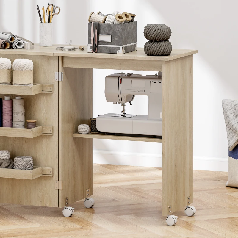 HOMCOM Mesa de costura dobrável móvel de costura com tampo rebatível, compartimentos de arrumação, prateleira aberta e rodízios, madeira natural